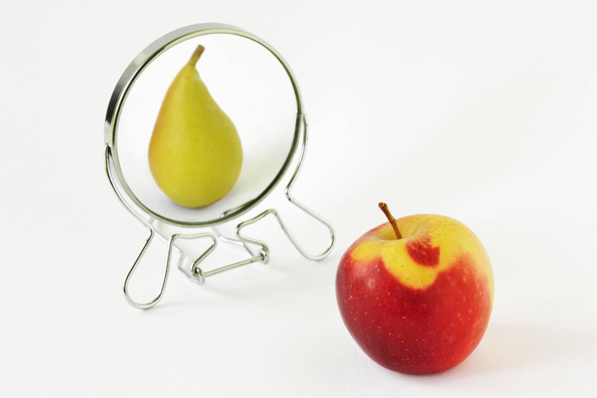 Apple looking at itself as a pear in a mirror (metaphor for body dysmorphia)